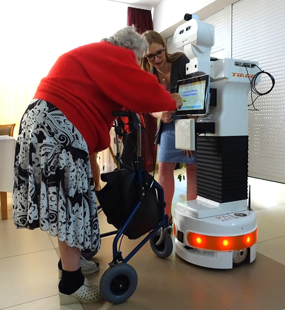 Older adult interacting with the TIAGo robot. Source: Photo taken by the researcher (processed with Adobe Photoshop version 13.0).
